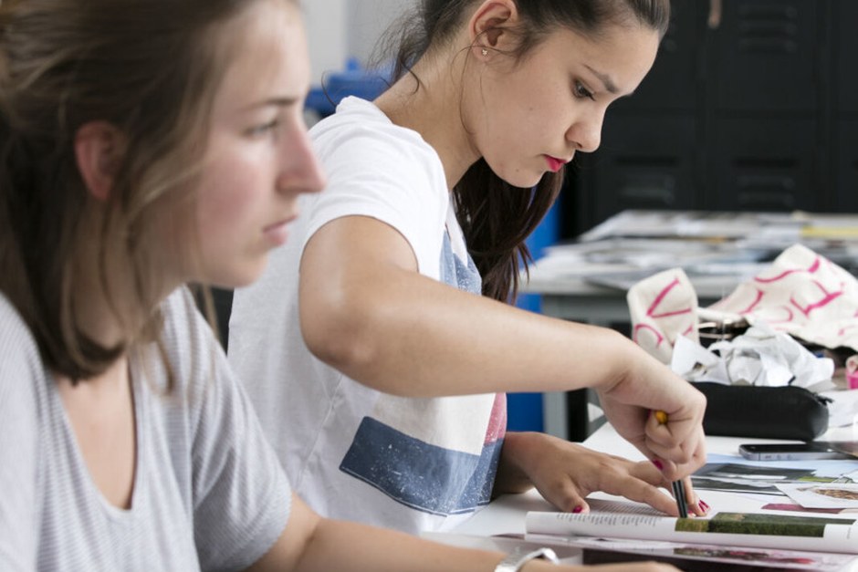 People working together on a hands-on creative activity at a shared table.